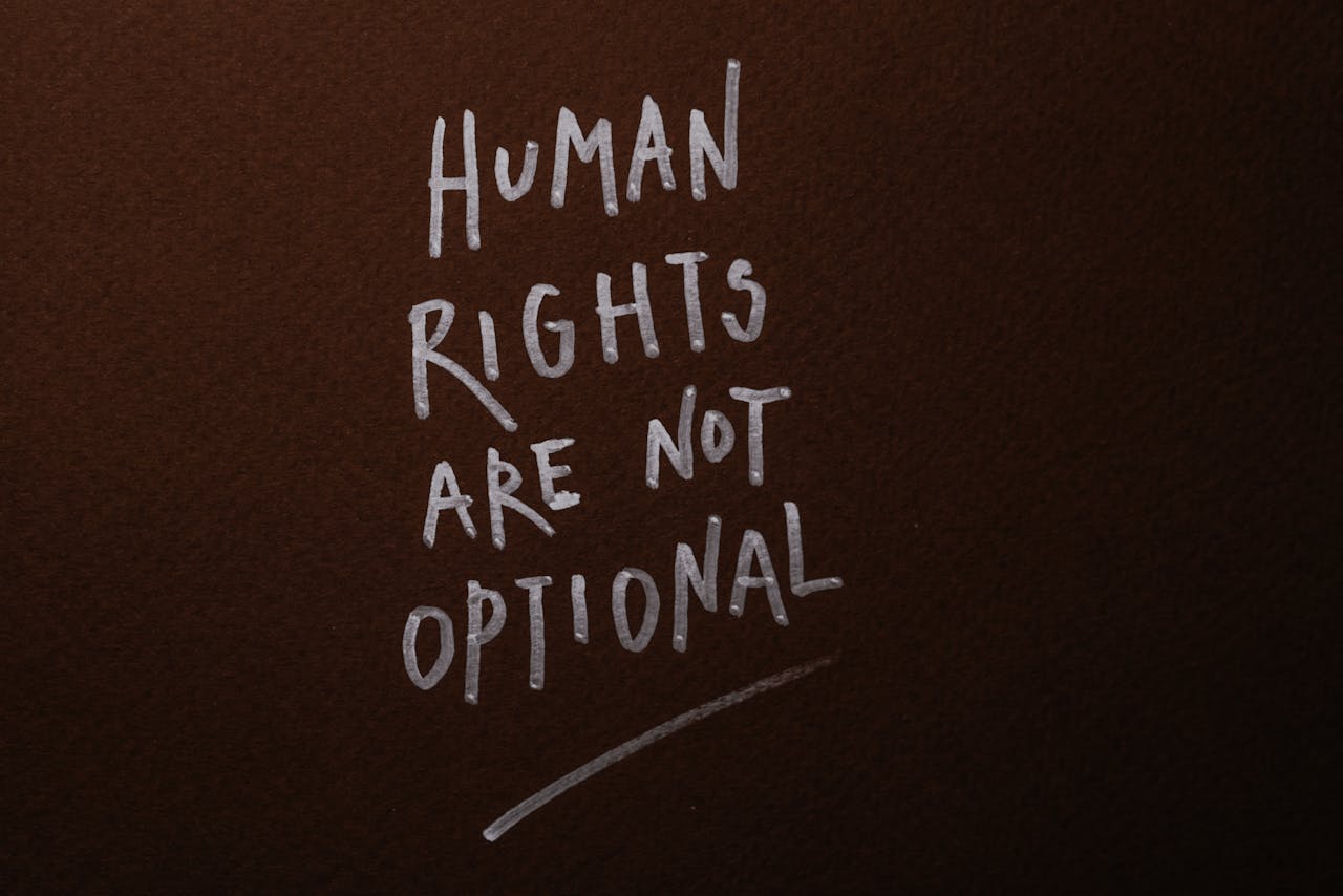 Services-02 Handwritten message advocating for human rights on a rich brown background.